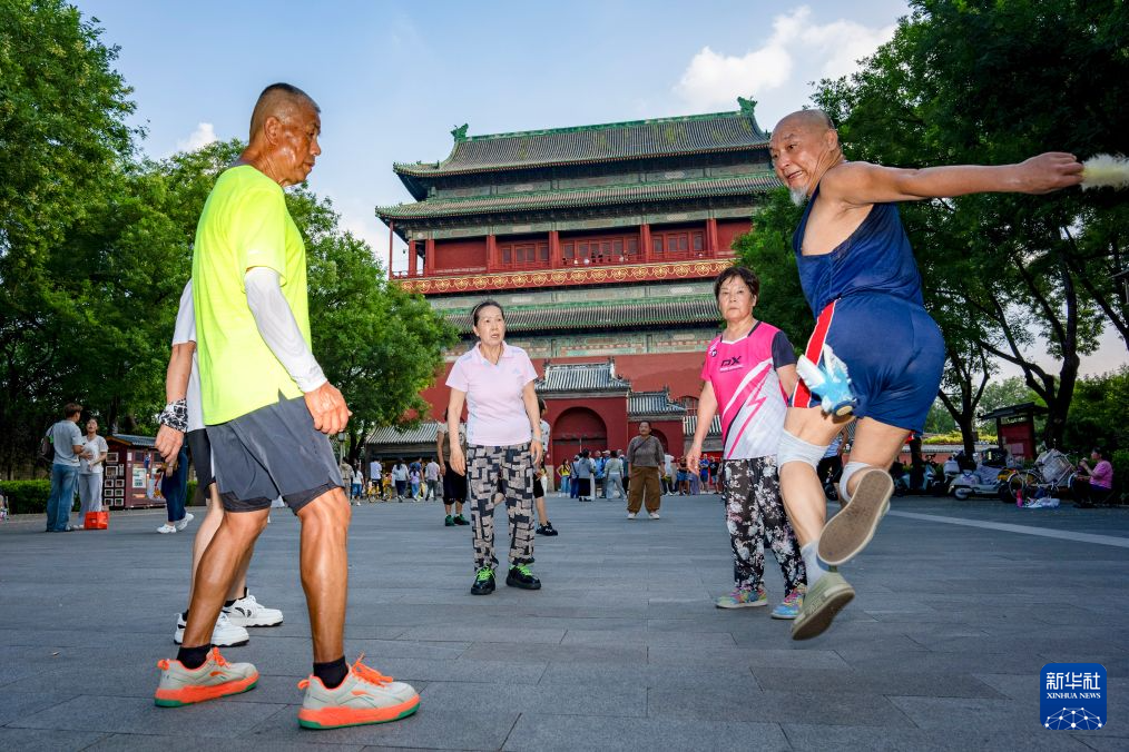 7月27日,市民在钟鼓楼广场踢毽子。